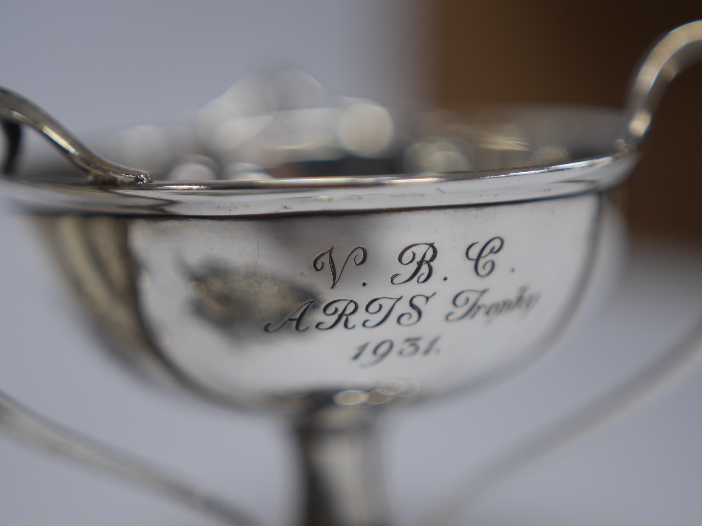 A George V silver spill vase, with pierced handles and stem, maker's mark rubbed, Birmingham, 1930, 16.6cm, together with a small silver tri-handled pedestal bowl, a small silver mug and Hanau white metal boat shaped sal